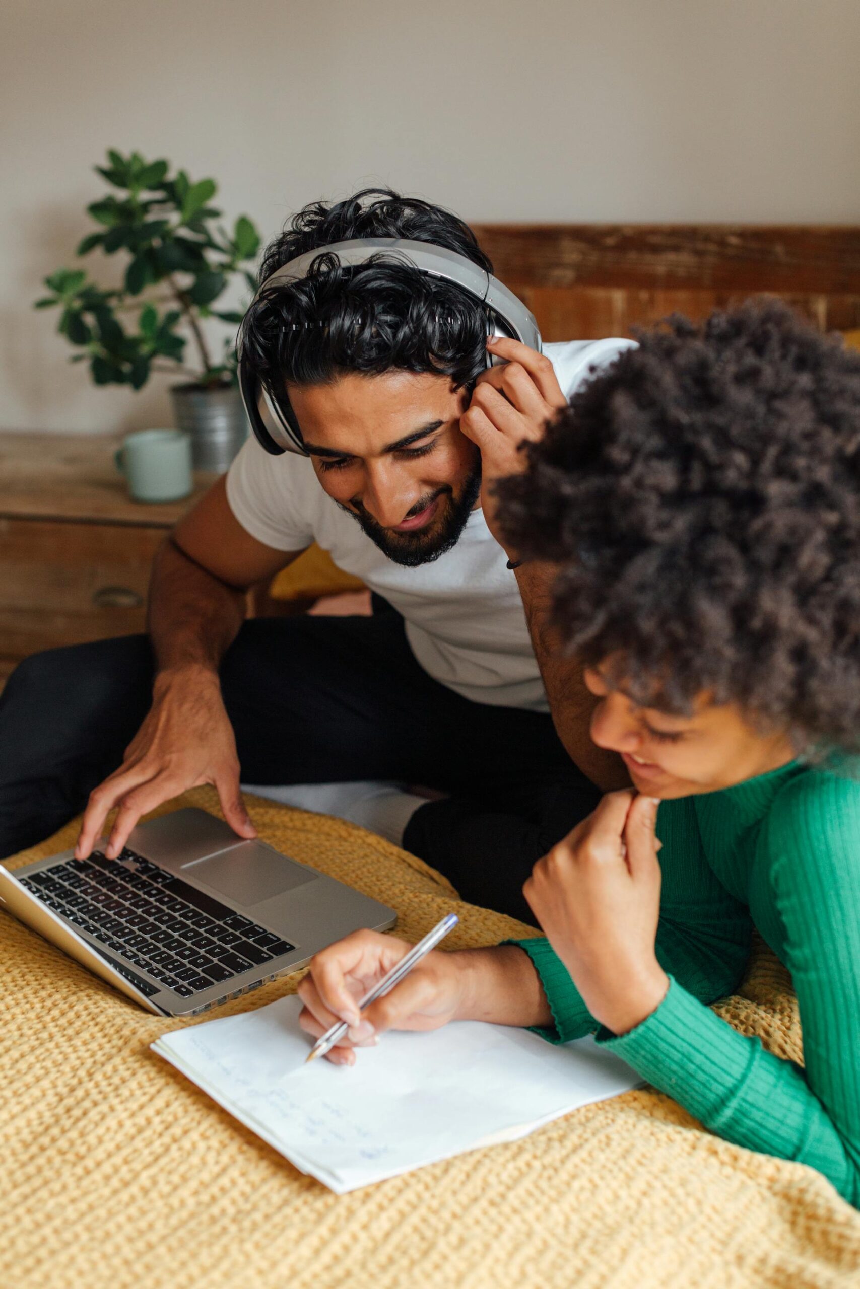 Couple discutant et travaillant sur un ordinateur pour préparer un projet immobilier à Paris.