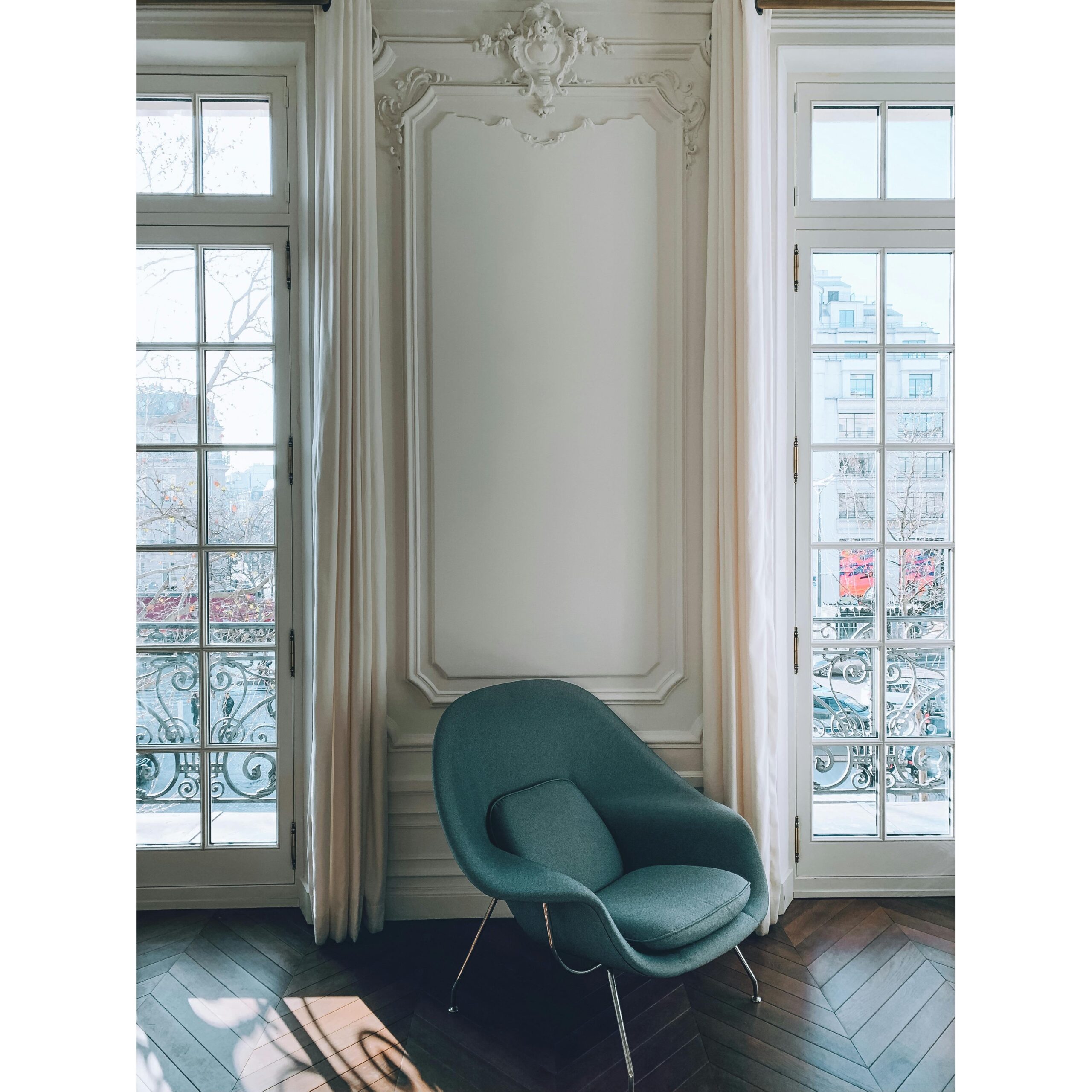 Intérieur d’un appartement haussmannien avec moulures et grandes fenêtres, illustrant l’élégance des biens proposés par Venor Immobilier à Paris, conjuguant charme de l’ancien et confort moderne